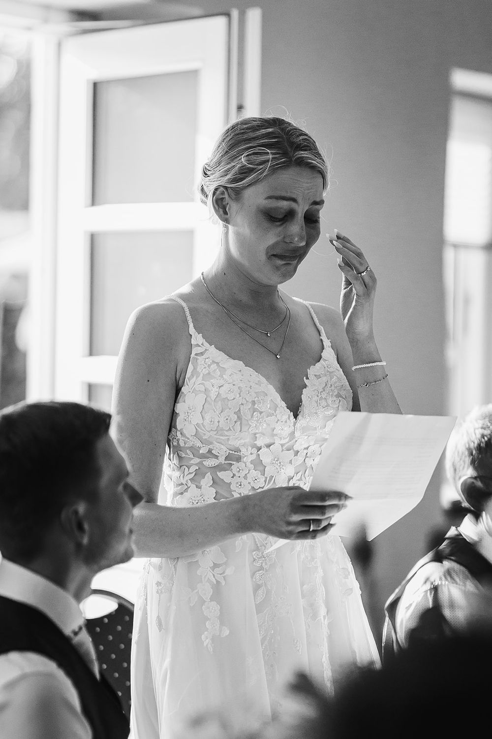 A series of emotional black and white wedding photos showing tender moments during a ceremony.