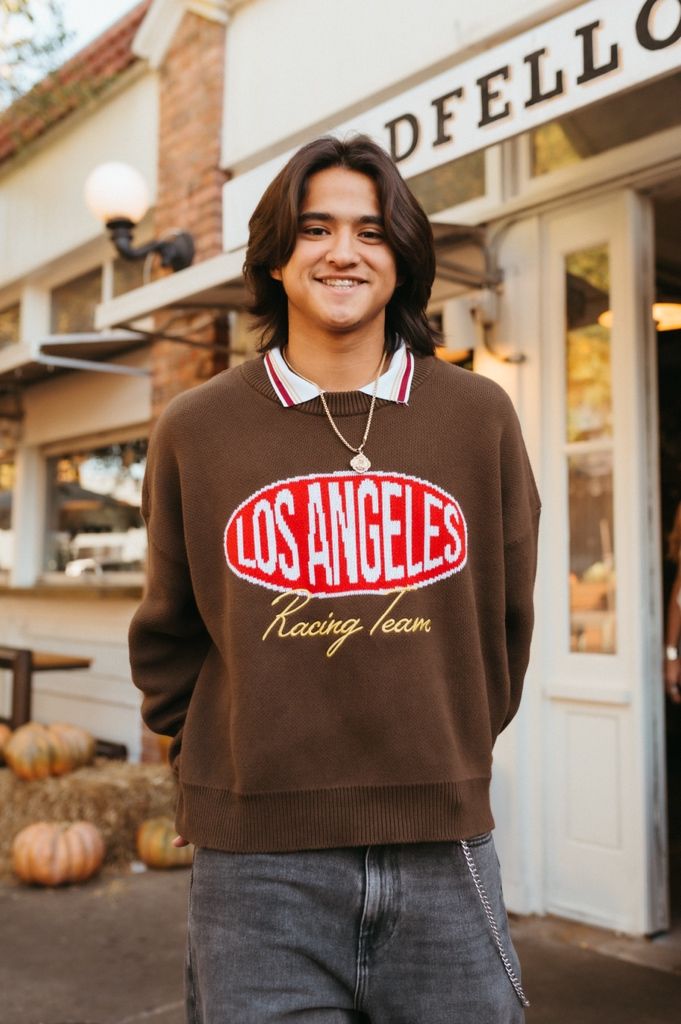 Multiple views of a brown Los Angeles sweatshirt styled with jeans in front of a brick storefront.