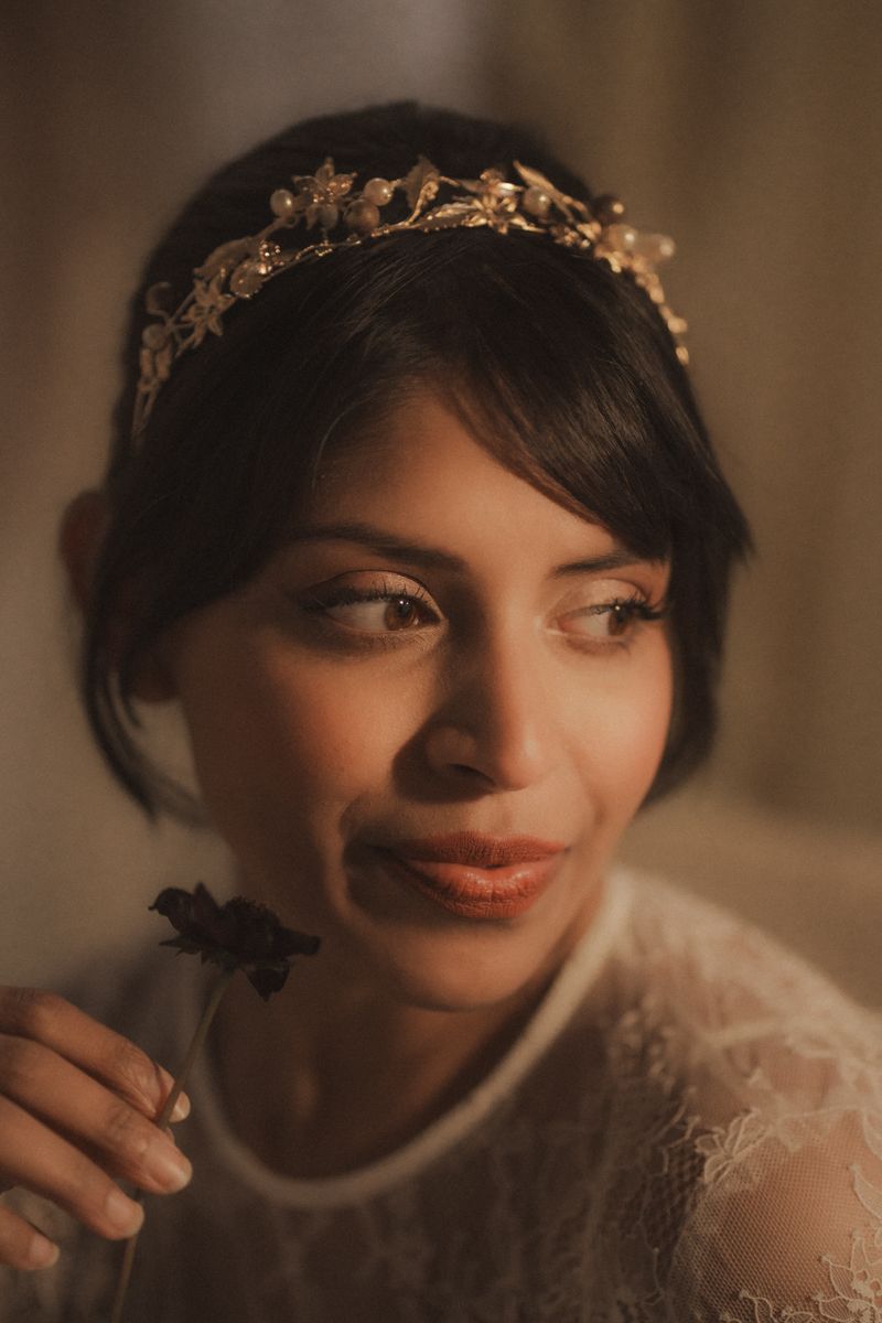 Close-up portrait of someone wearing a delicate lace veil in warm, romantic lighting.