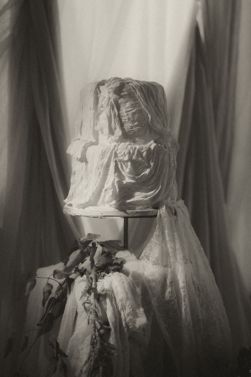 A series of black and white photographs showing a draped white fabric creating dramatic shadows and texture.