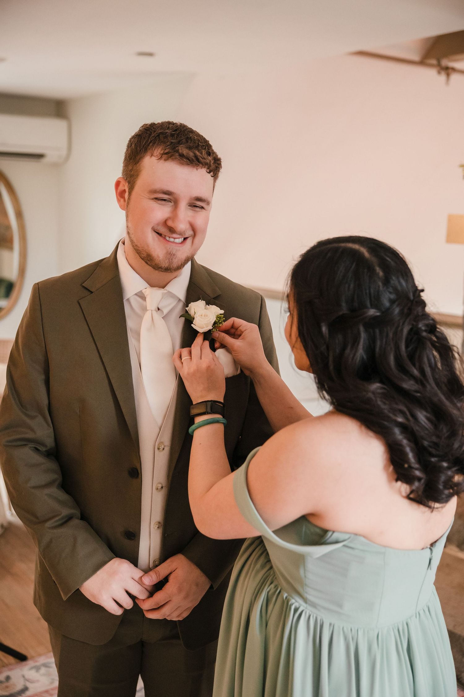 Boutonniere being pinned on groom during getting ready at Briar Barn Inn wedding Massachusetts