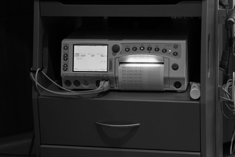 Black and white photo of vintage electronic test equipment on a metal cart with drawer.