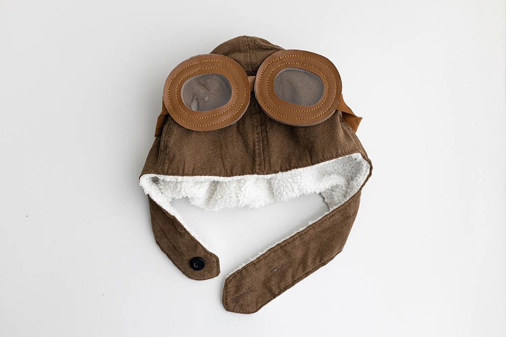 Vintage brown leather aviator pilot hat with goggles for milestone baby photography in Moreno Valley.