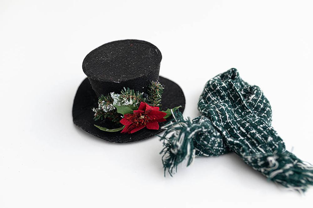 Christmas themed baby photography props; Black glitter mini top hat with holiday poinsettia decoration and green plaid scarf.