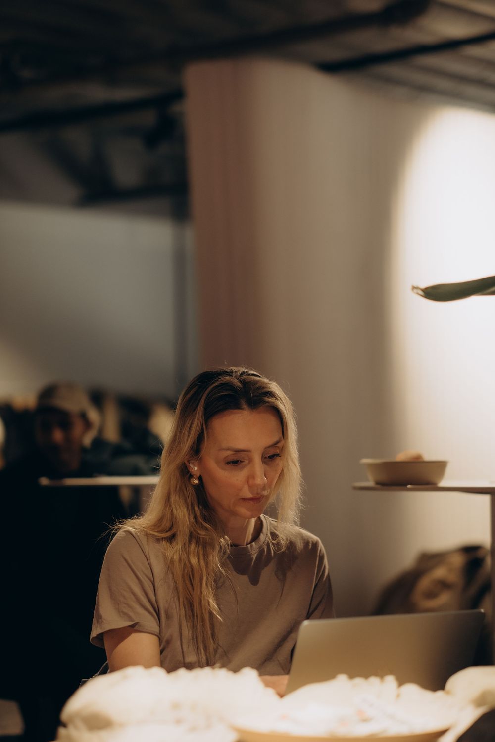 woman sitting behind computer focusing on coding while being captured by best event photographer in Stockholm