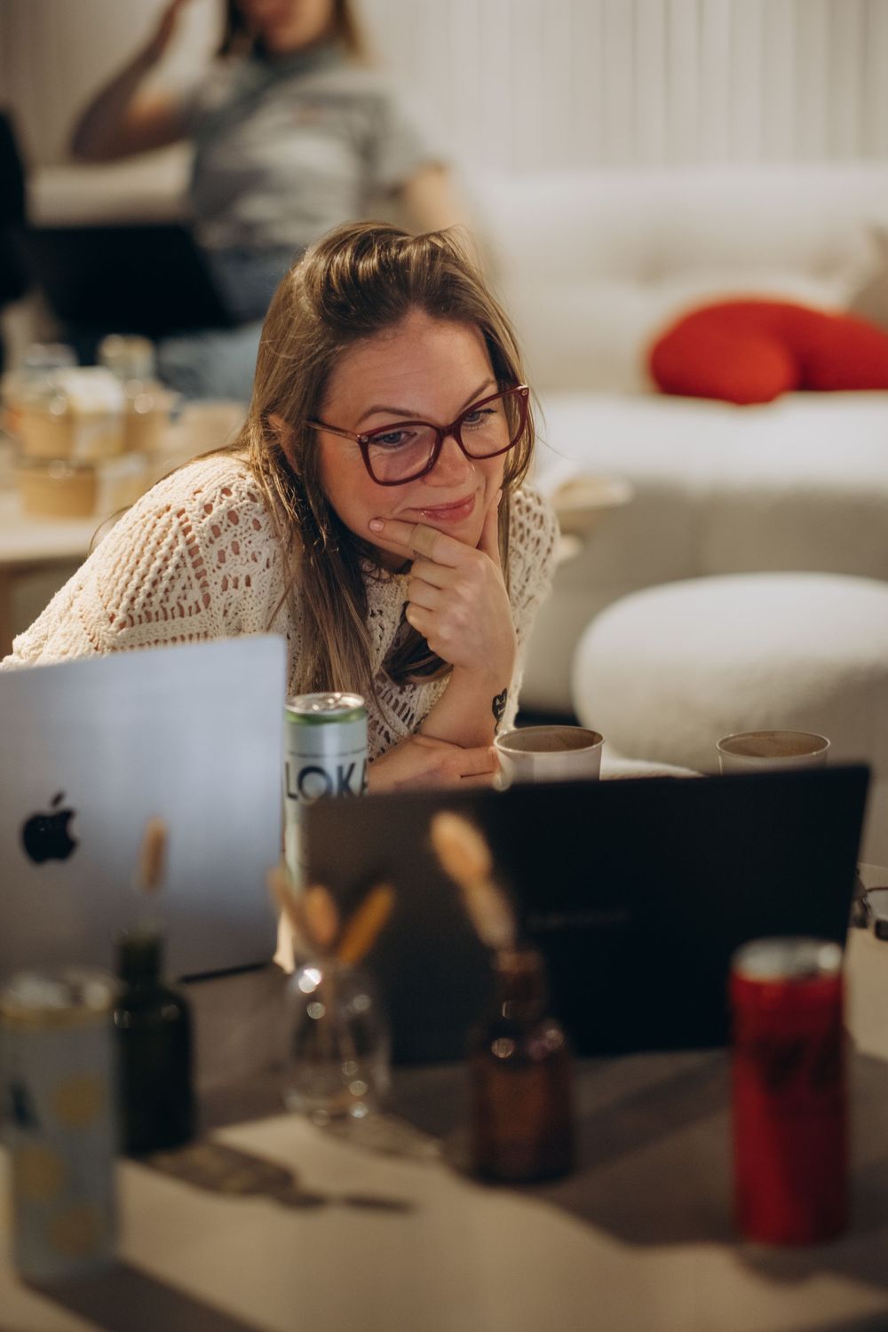 woman sitting on a floor looking into her laptop while being captured by photographer offering event photography services in Stockholm