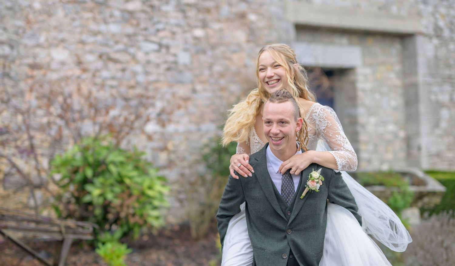 A romantic wedding couple poses in a series of elegant shots under stone archways at a historic European castle.