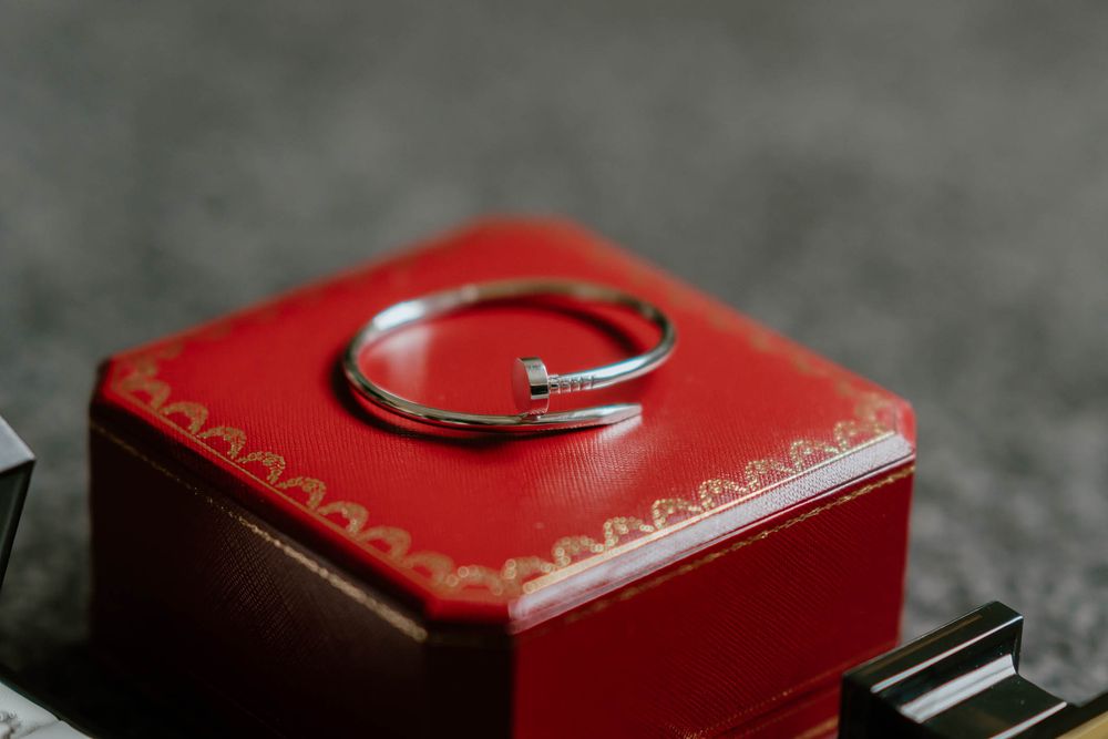 Luxury Cartier Juste un Clou silver nail bracelet displayed on its iconic red gift box.