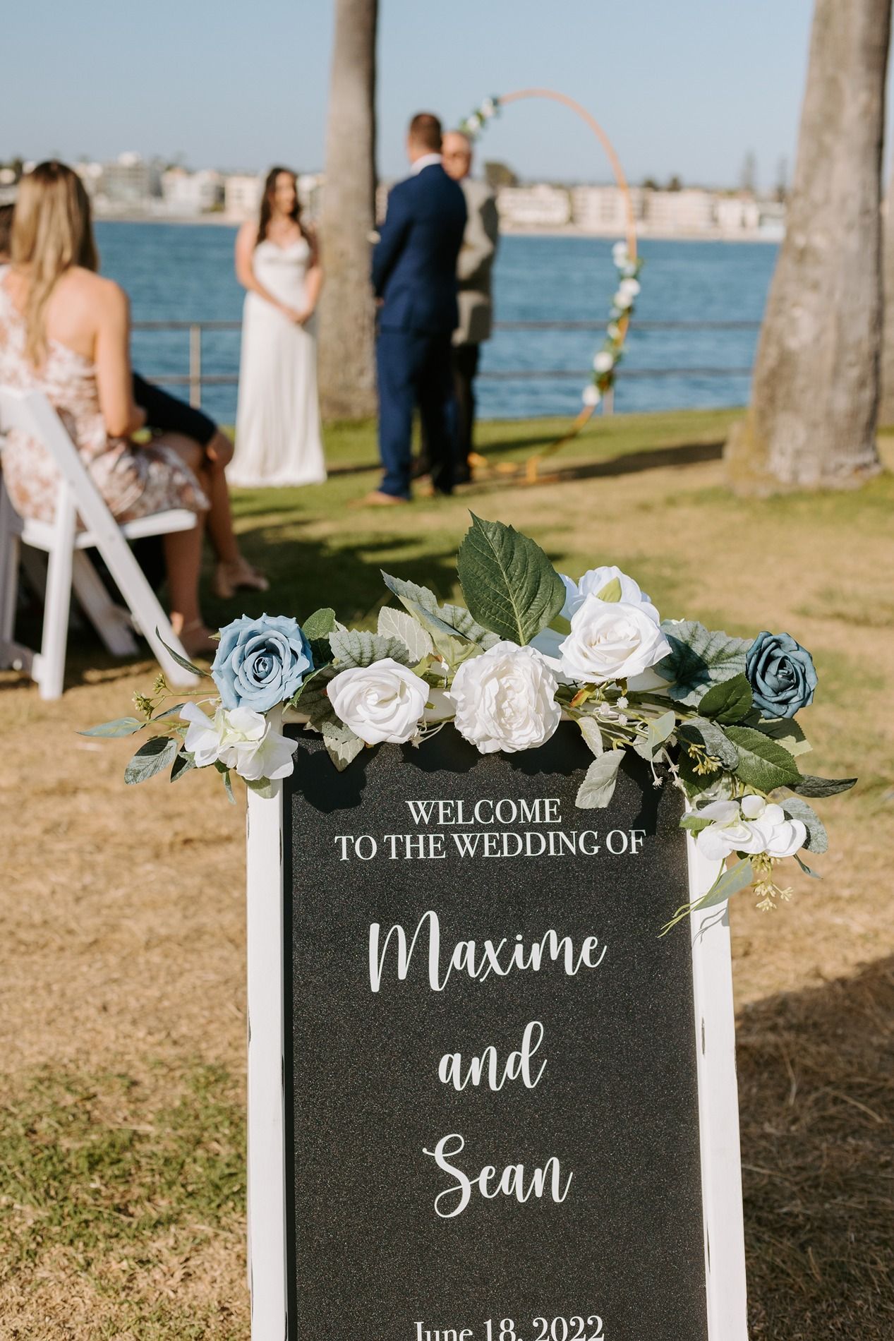 Outdoor wedding ceremony sign welcoming guests to Maxime and Sean's waterfront wedding on June 18, 2022 at Tower Beach Club.