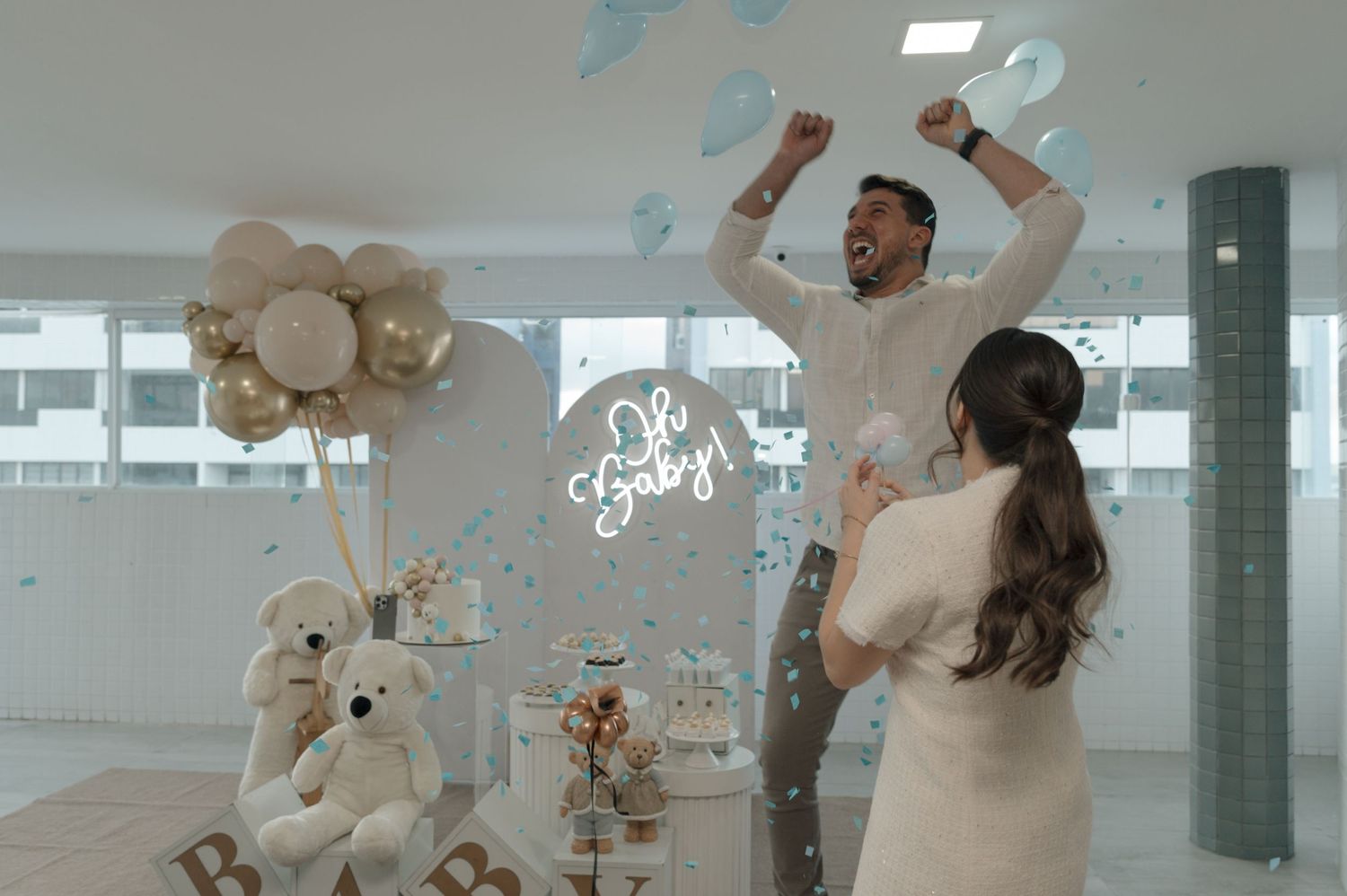 A festive baby shower celebration with balloon decorations and plush toys in an indoor setting.