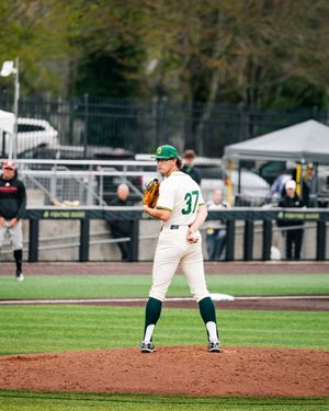 Baseball pitcher in green and white uniform number 37 stands on the mound ready to deliver a pitch.