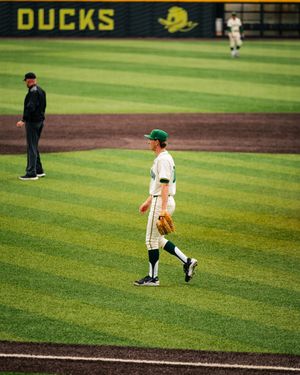 Oregon Ducks baseball player in green uniform walking on the field during a game at PK Park.