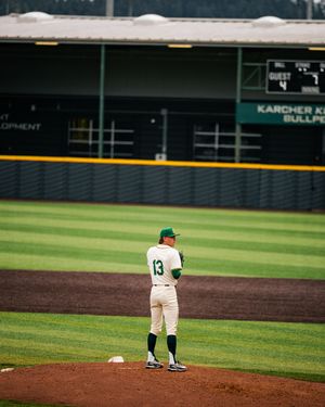 Baseball player wearing number 13 stands on the mound at Karcher Field during a college baseball game.