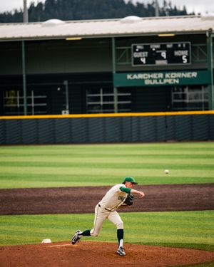 Baseball pitcher in green uniform mid-throw at Karcher Korner Bullpen stadium during a game.