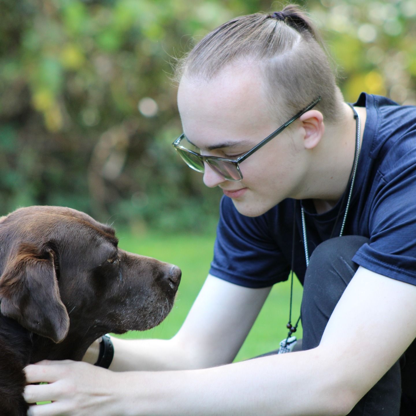 Person interacting with their dog during a natural outdoor pet and portrait photography session