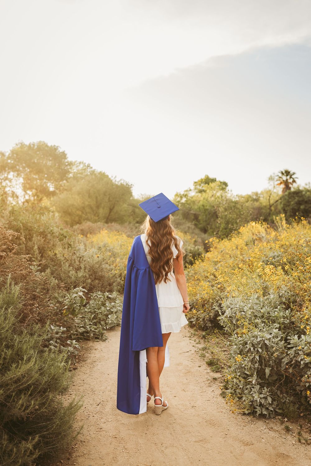 Graduate in cap and gown stands for photos in redlands ca with heidi grace photography