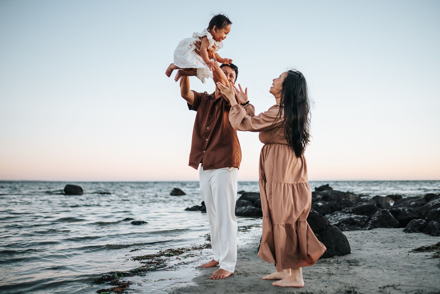 Candid family moments with the father lifting up a young toddler and playing with the mother taken by a Melbourne family photographer.