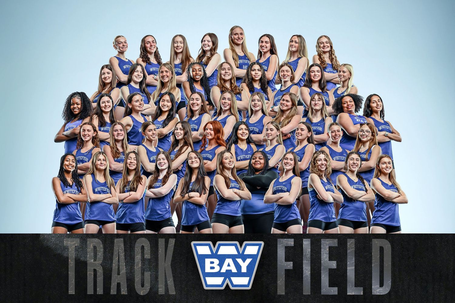 Bay W Track and Field womens team poses together in blue uniforms for an official group photo.
