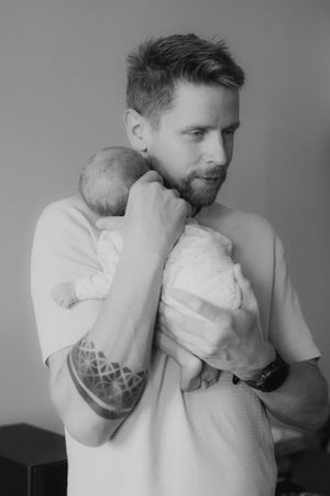Portrétní fotografie tatínka držící miminko v ateliéru