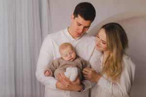 Rodiče drží miminko v náručí při focení