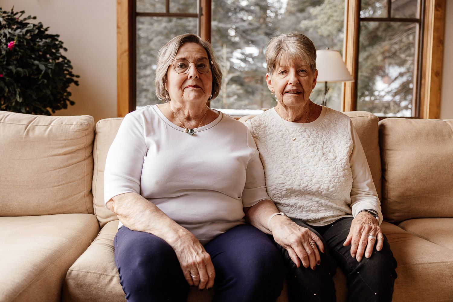 Two women sit on a couch for their extended family photo session in Tahoe Donner