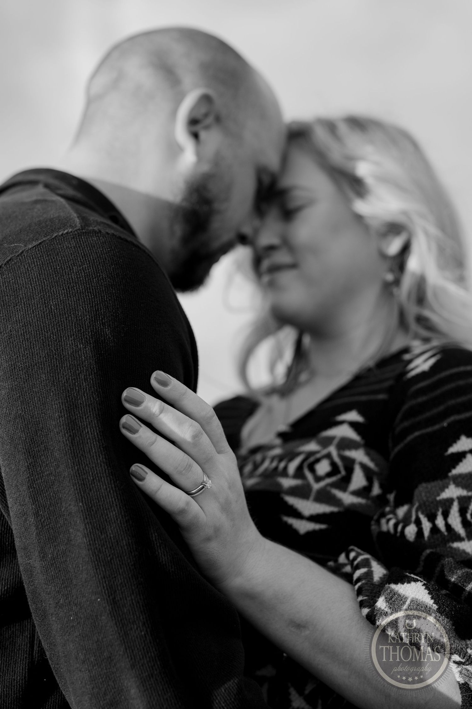 An intimate black and white close-up of a couple sharing a tender moment.