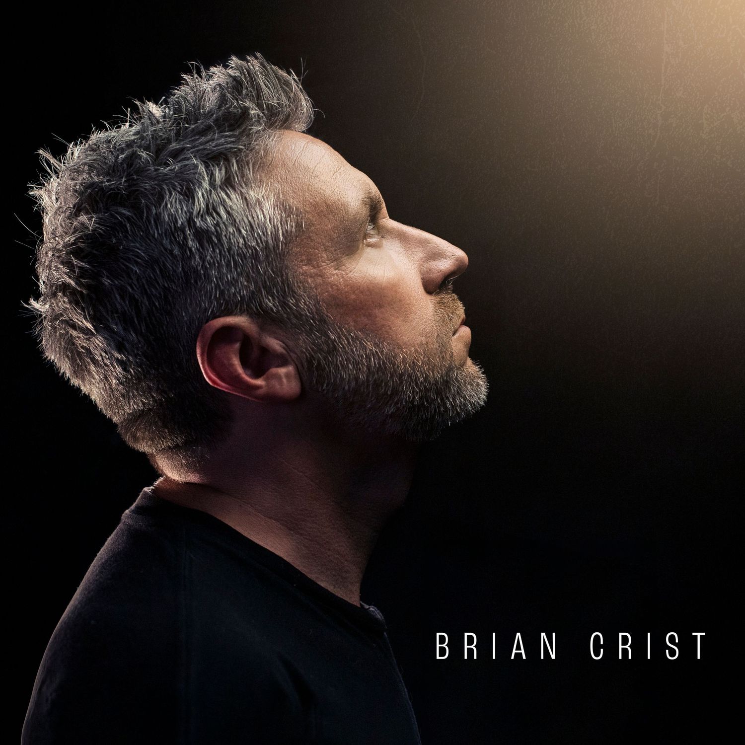 Profile portrait of Brian Crist with dramatic side lighting against dark background.