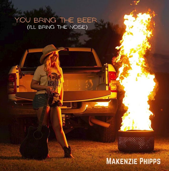 Artist Makenzie Phipps stands near pickup truck with dramatic bonfire at night for album cover 'You Bring The Beer'.