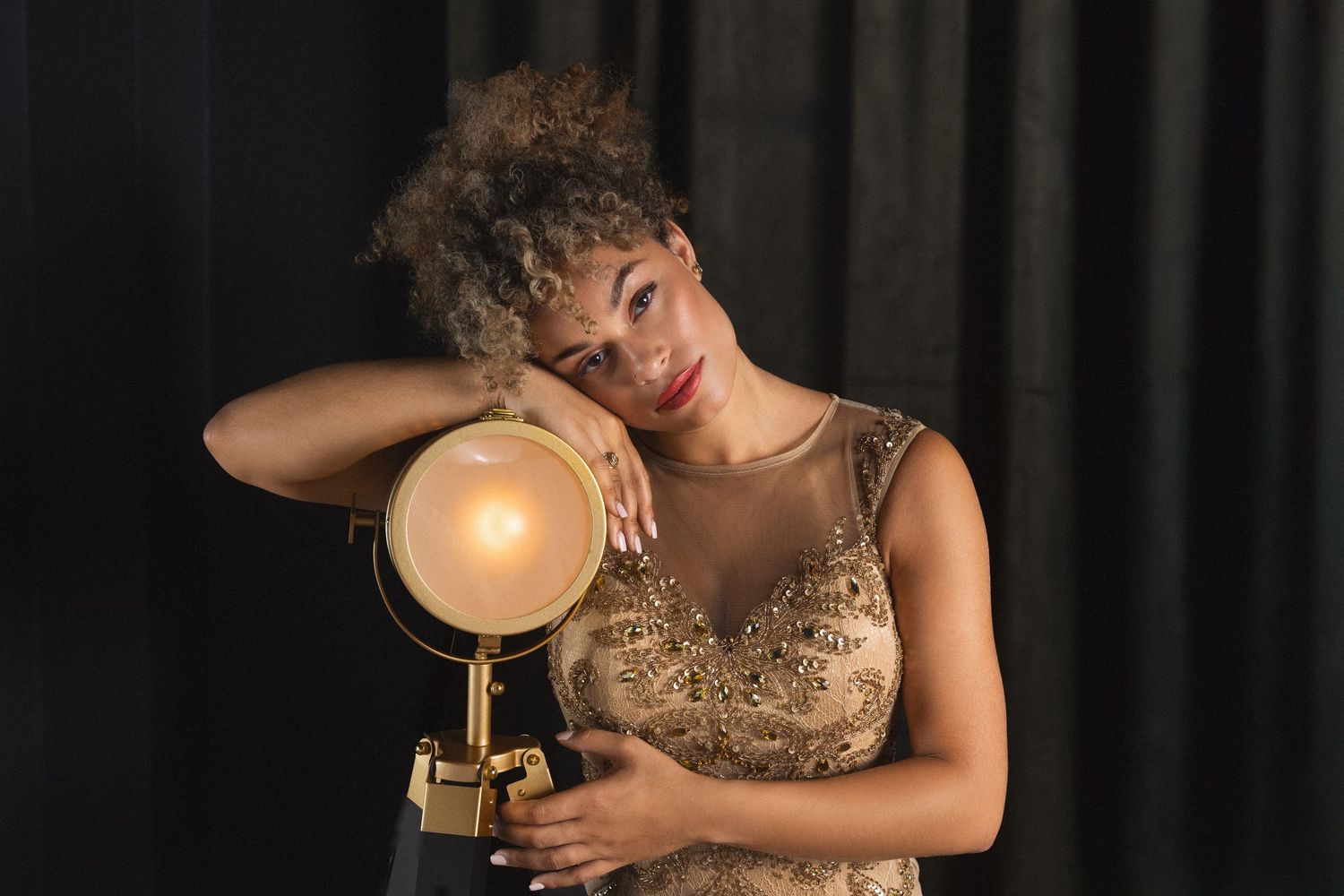 A sequence of photos shows a person wearing a gold dress posing with dramatic lighting and holding a glass of wine.