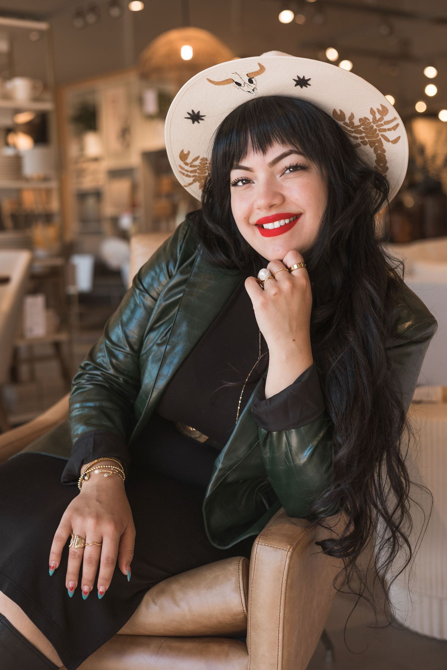 Cozy cafe portrait wearing patterned hat and green jacket in warm lighting.