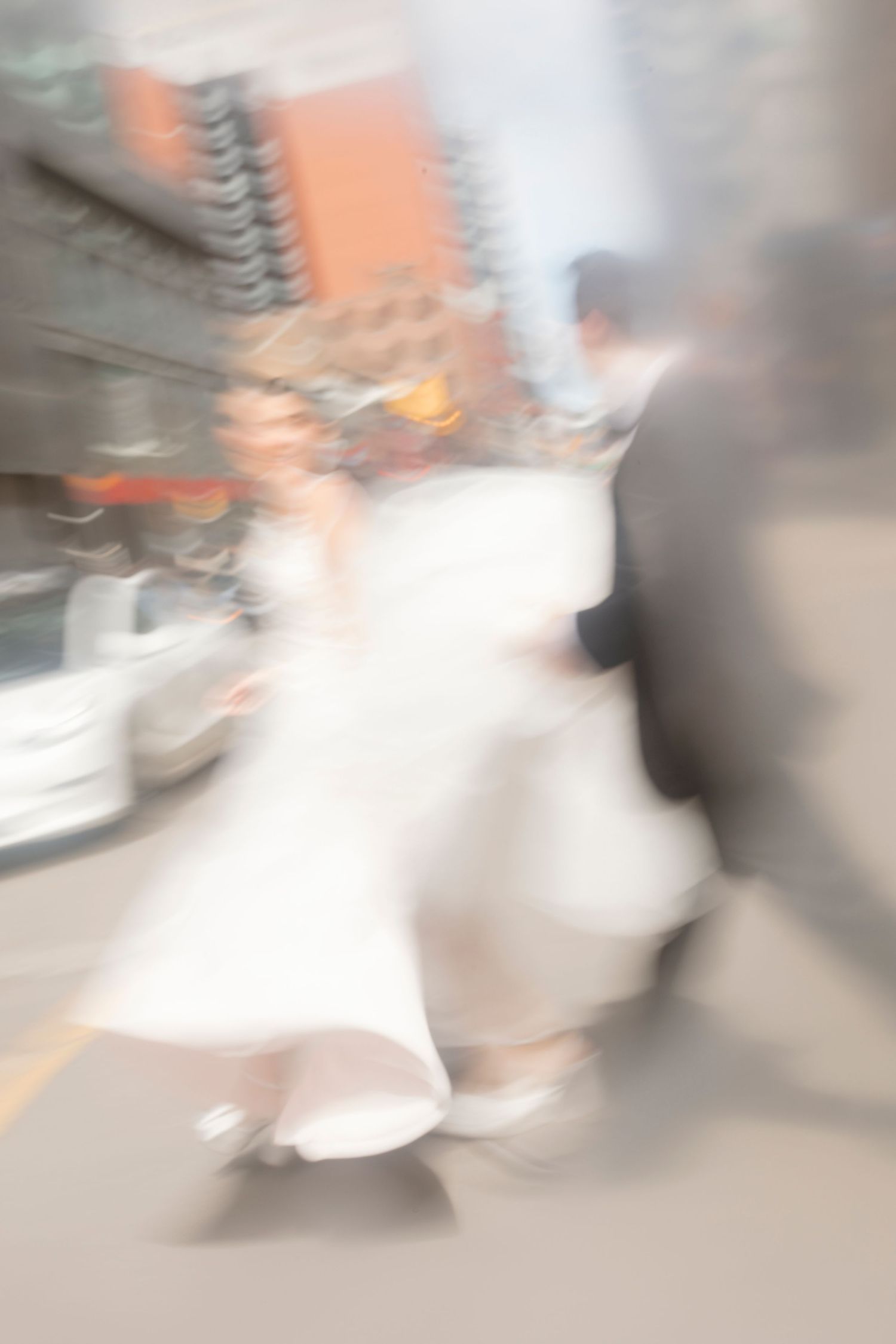 A bride and groom pose for a romantic sunset photo on a waterfront pier.