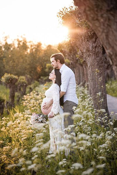 A romantic couple embraces in a dreamy meadow of white wildflowers during golden hour sunset near Rotterdam, Netherlands