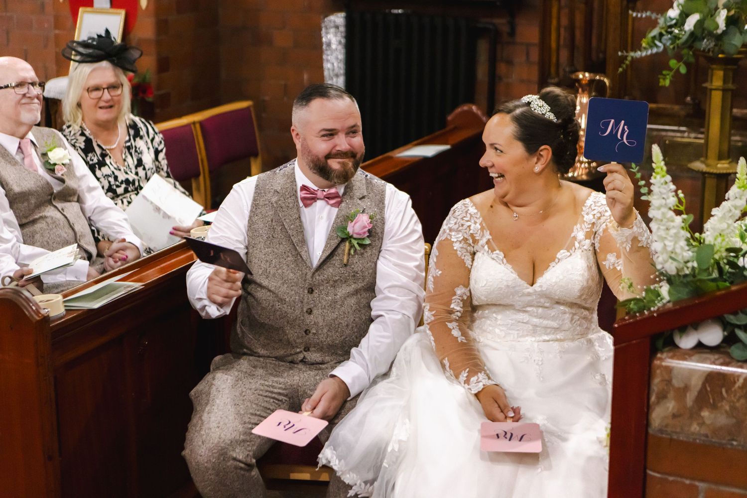 Happy guests share joyful moments during a wedding reception celebration in an indoor venue.