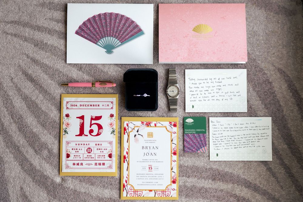 Wedding invitation cards and RSVP notes arranged on a gray textured background with decorative elements.