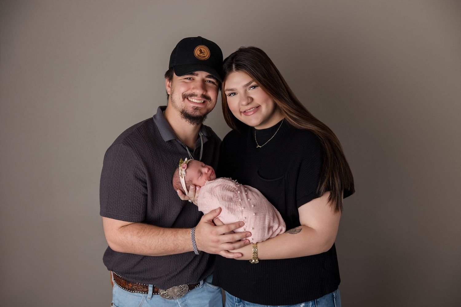 A series of six casual portraits featuring a couple with their newborn baby in muted neutral tones.