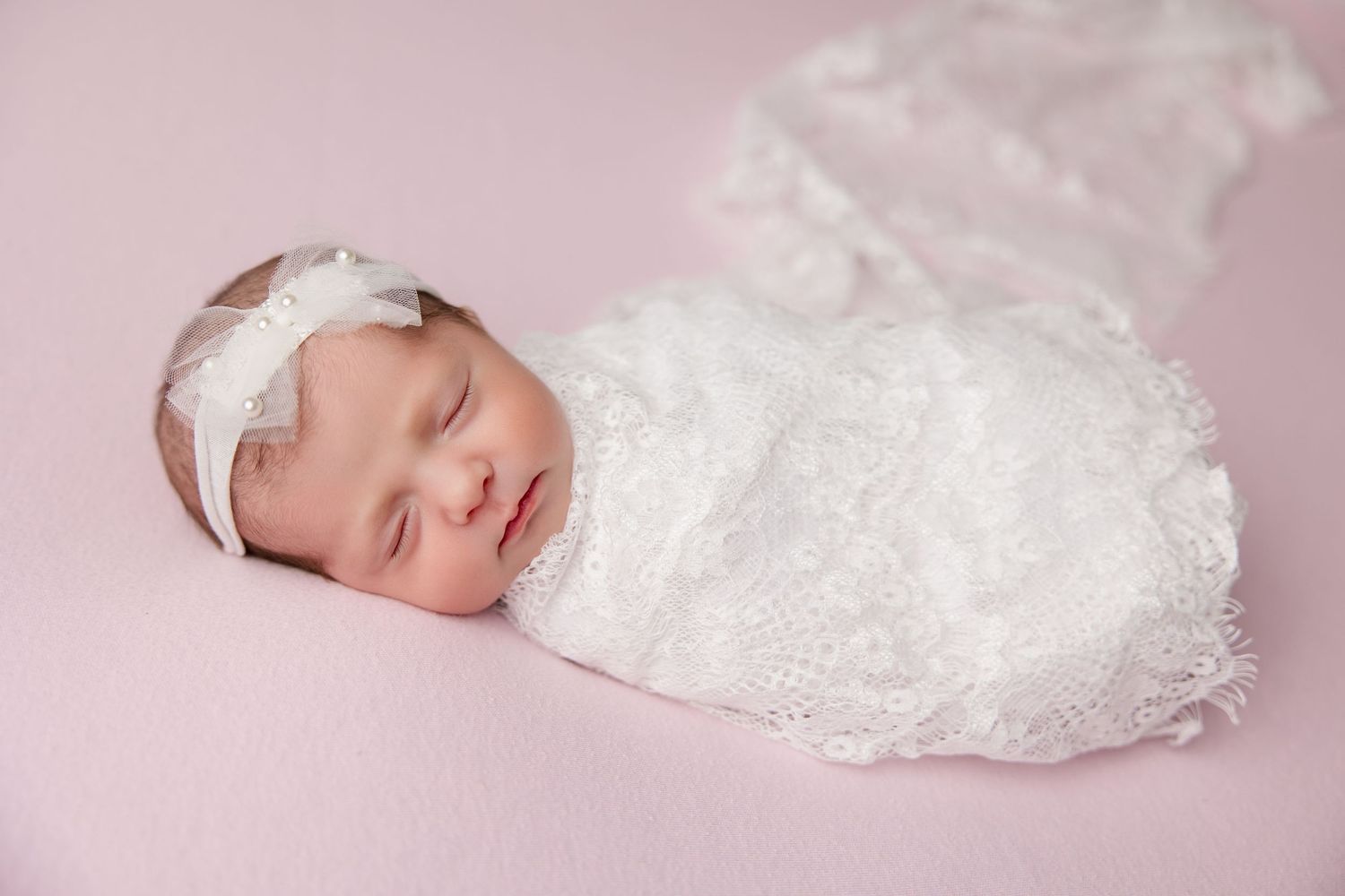 Six delicate newborn photography scenes arranged in a soft pink collage with white lace accents.