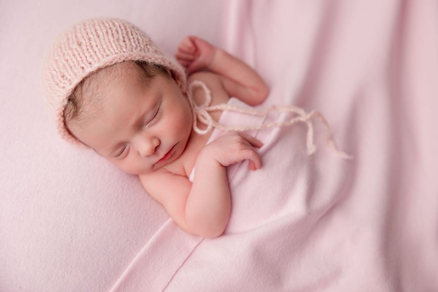 A collage of peaceful sleeping newborn baby photography captured in soft pink tones.