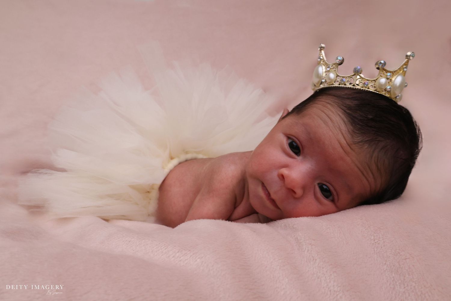 A sleeping newborn baby wrapped in soft pink blankets rests peacefully in a series of tender poses.