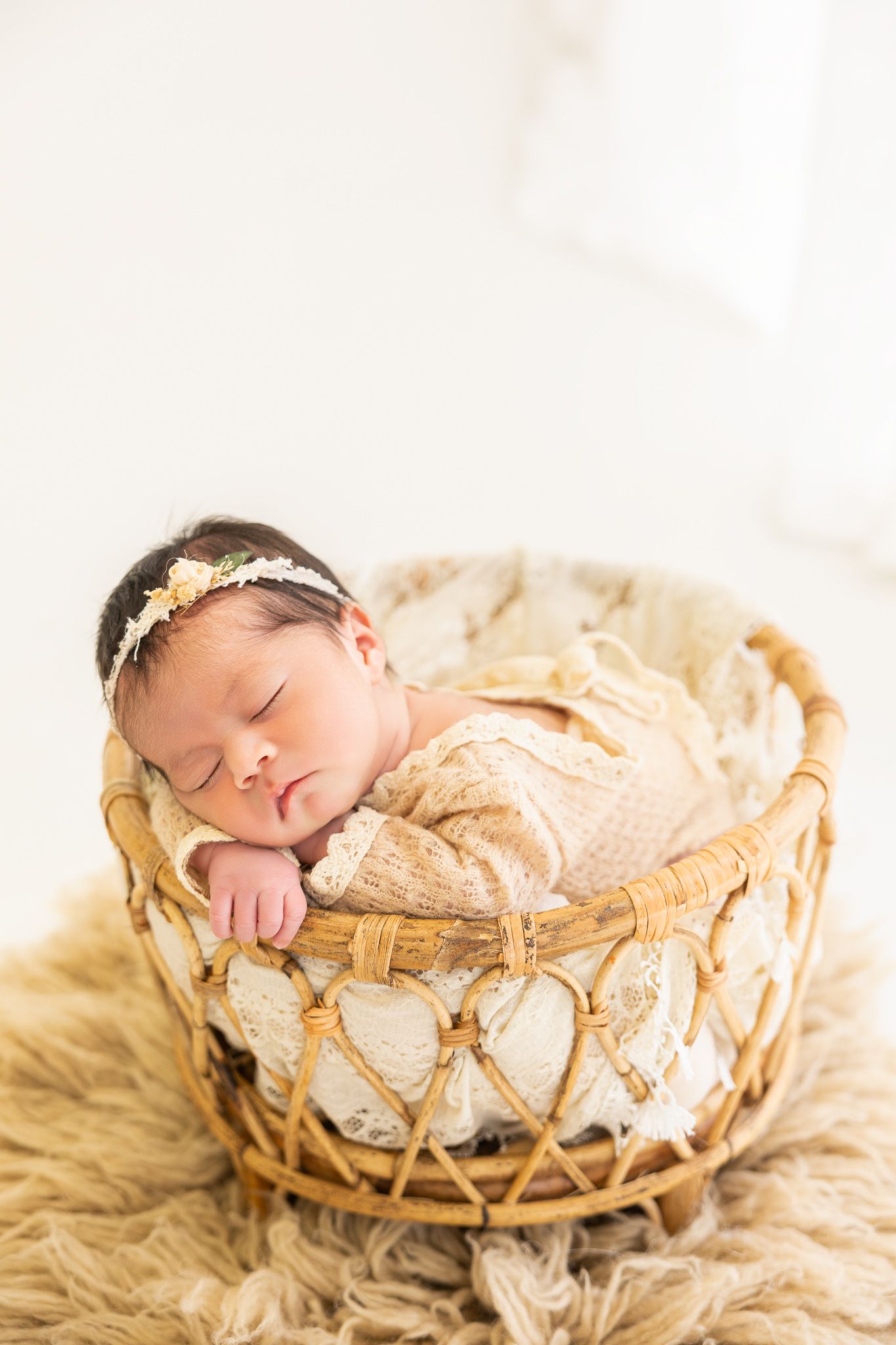 A series of four soft focus photos showing a sleeping newborn on a blue blanket with a wicker chair.