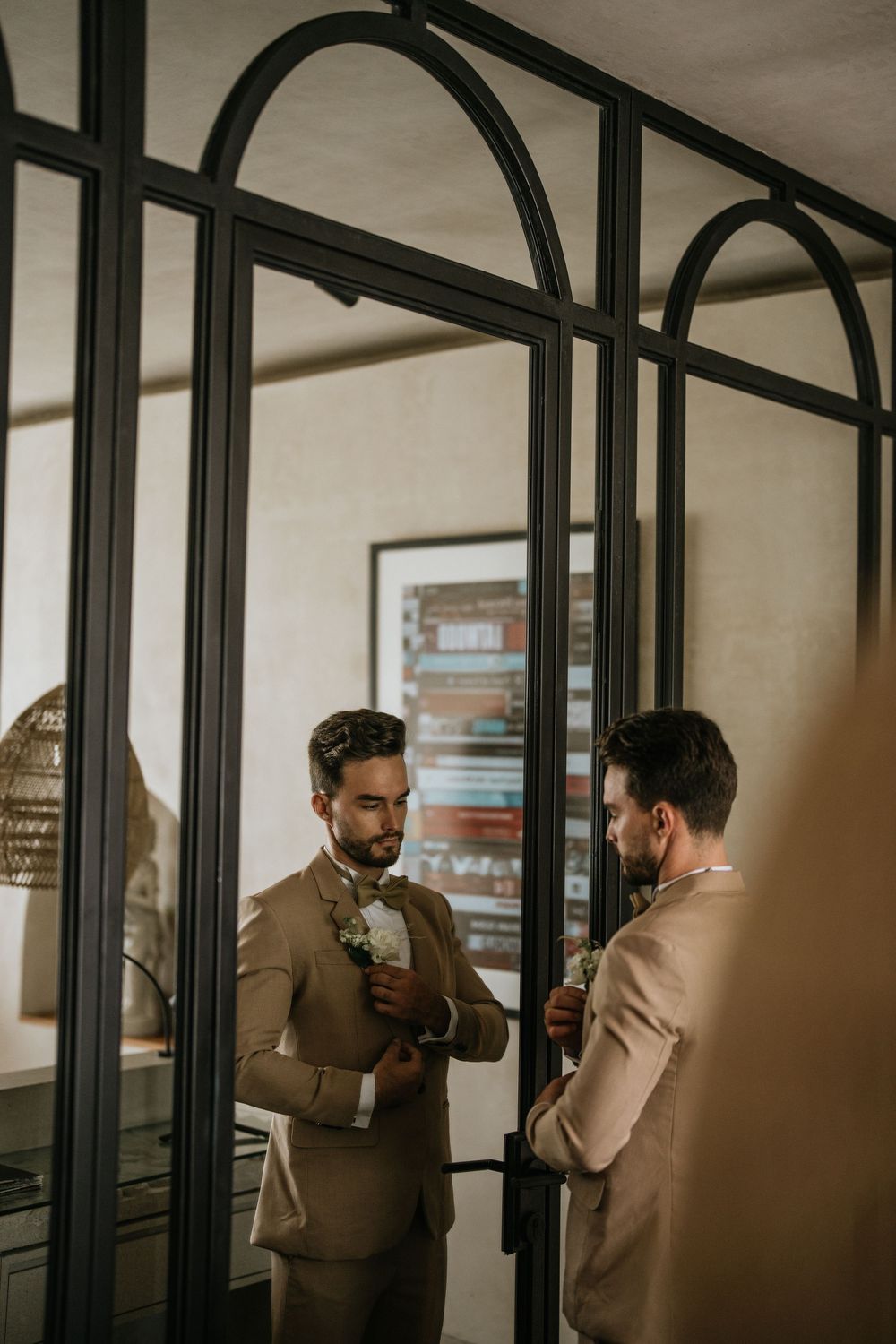 Wedding preparations in an elegant room with arched mirrors.