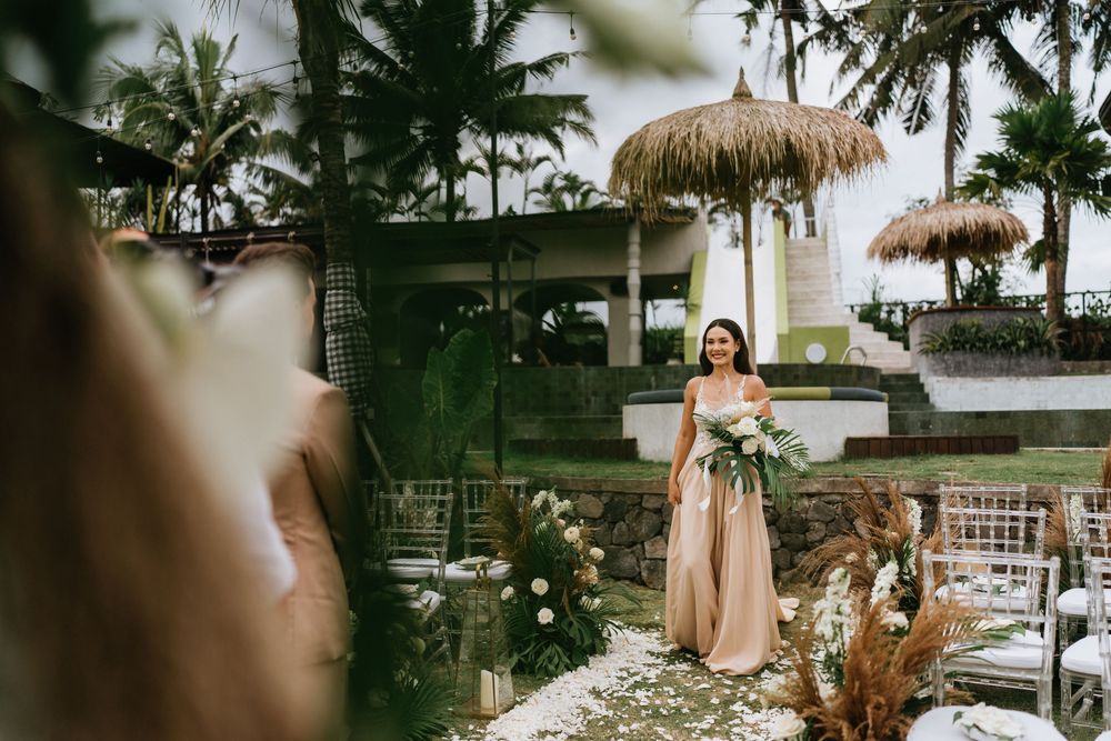 Elegant outdoor wedding setup with tropical palm trees and blush decor elements.