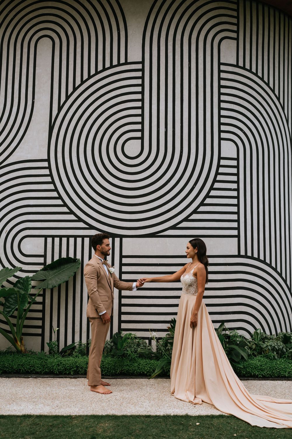 Wedding couple poses against modern black and white geometric wall art.
