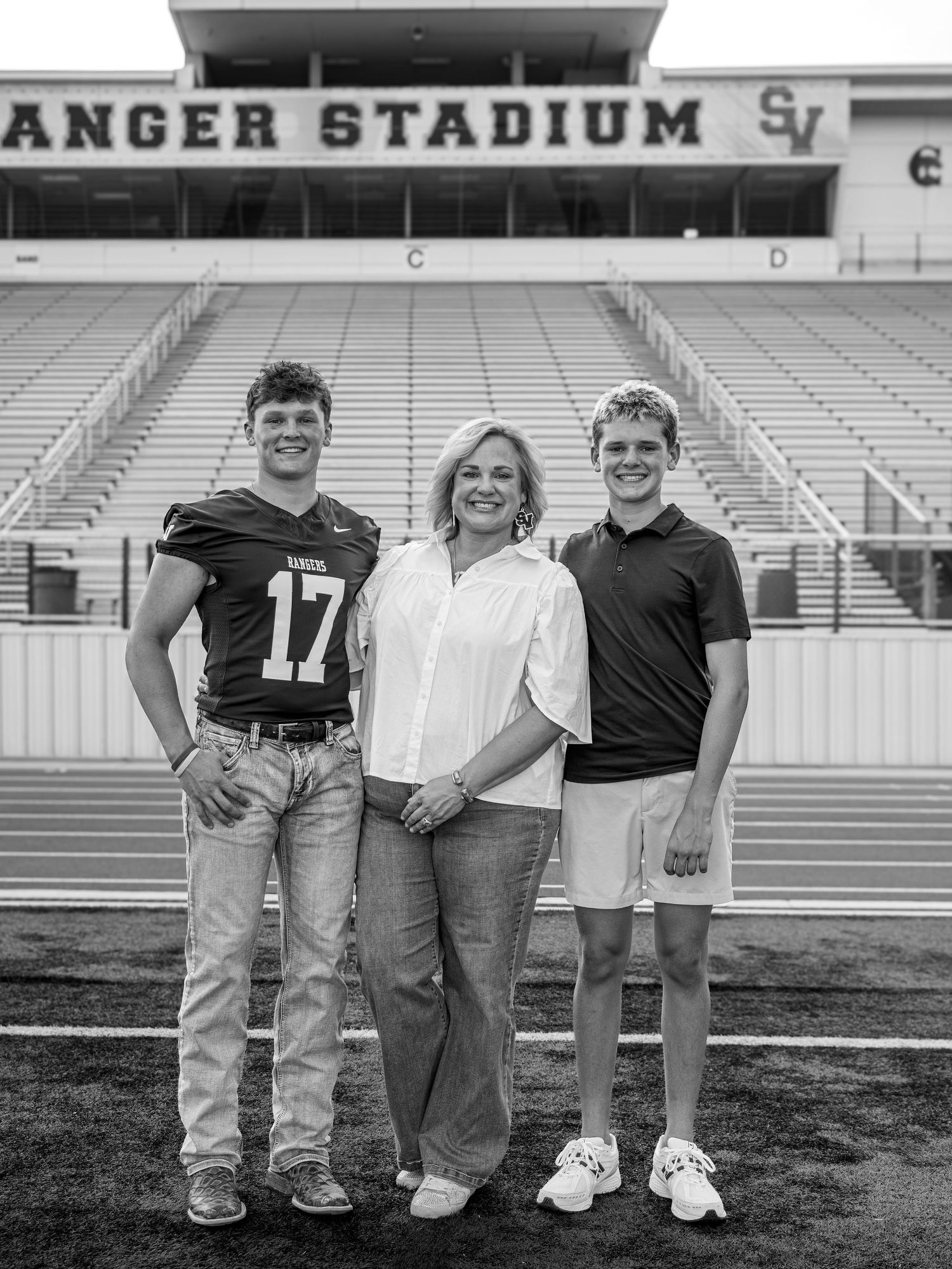 Family portrait at Ranger Stadium with football bleachers in the background.