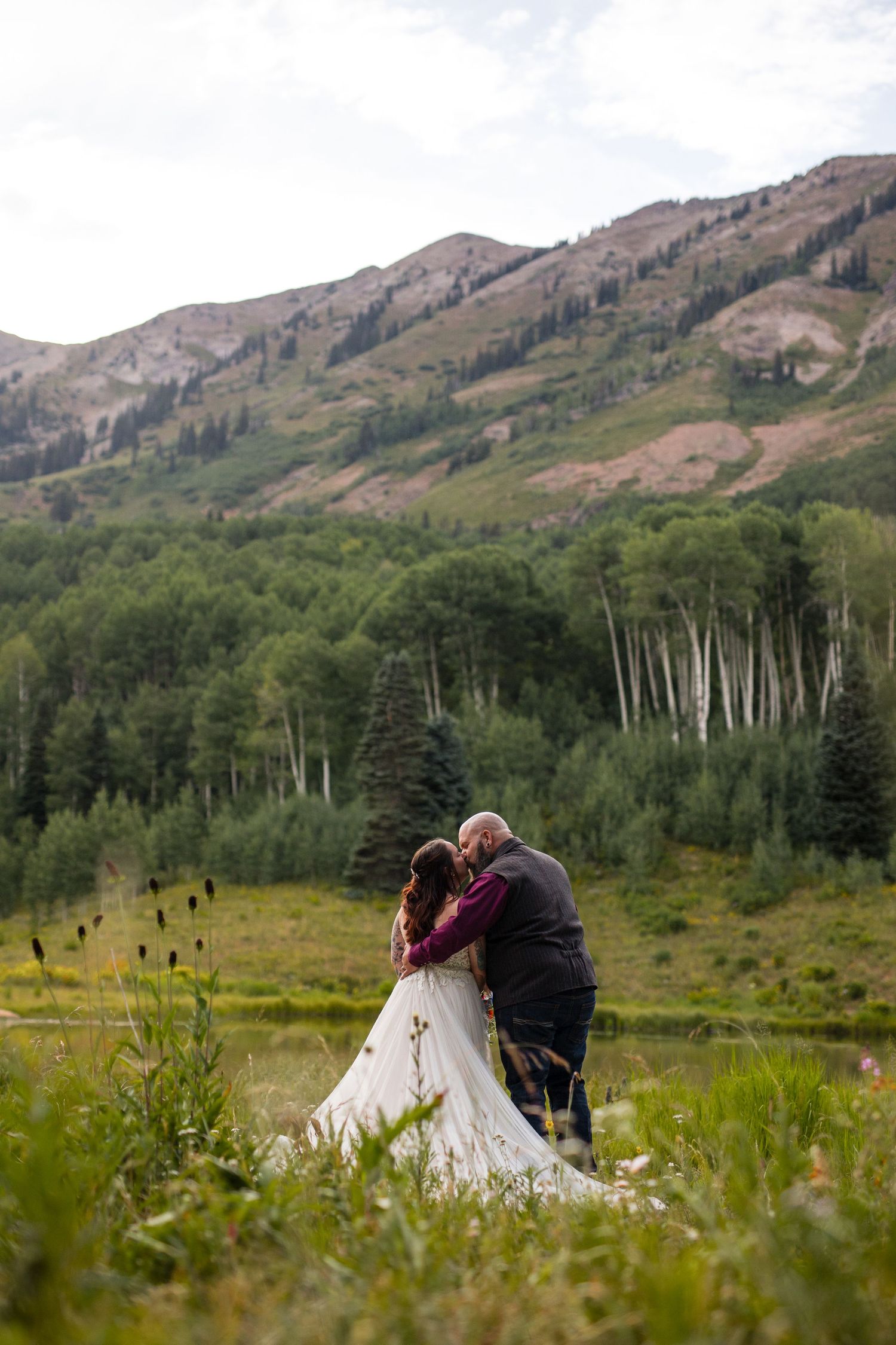Two teepees nestled in a meadow with aspen trees and mountains in the scenic Colorado wilderness.