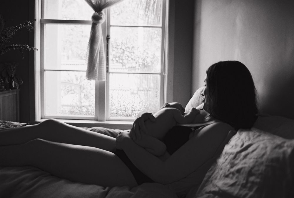 Sunlight streams through a window in a dark interior room creating dramatic lighting and shadows.