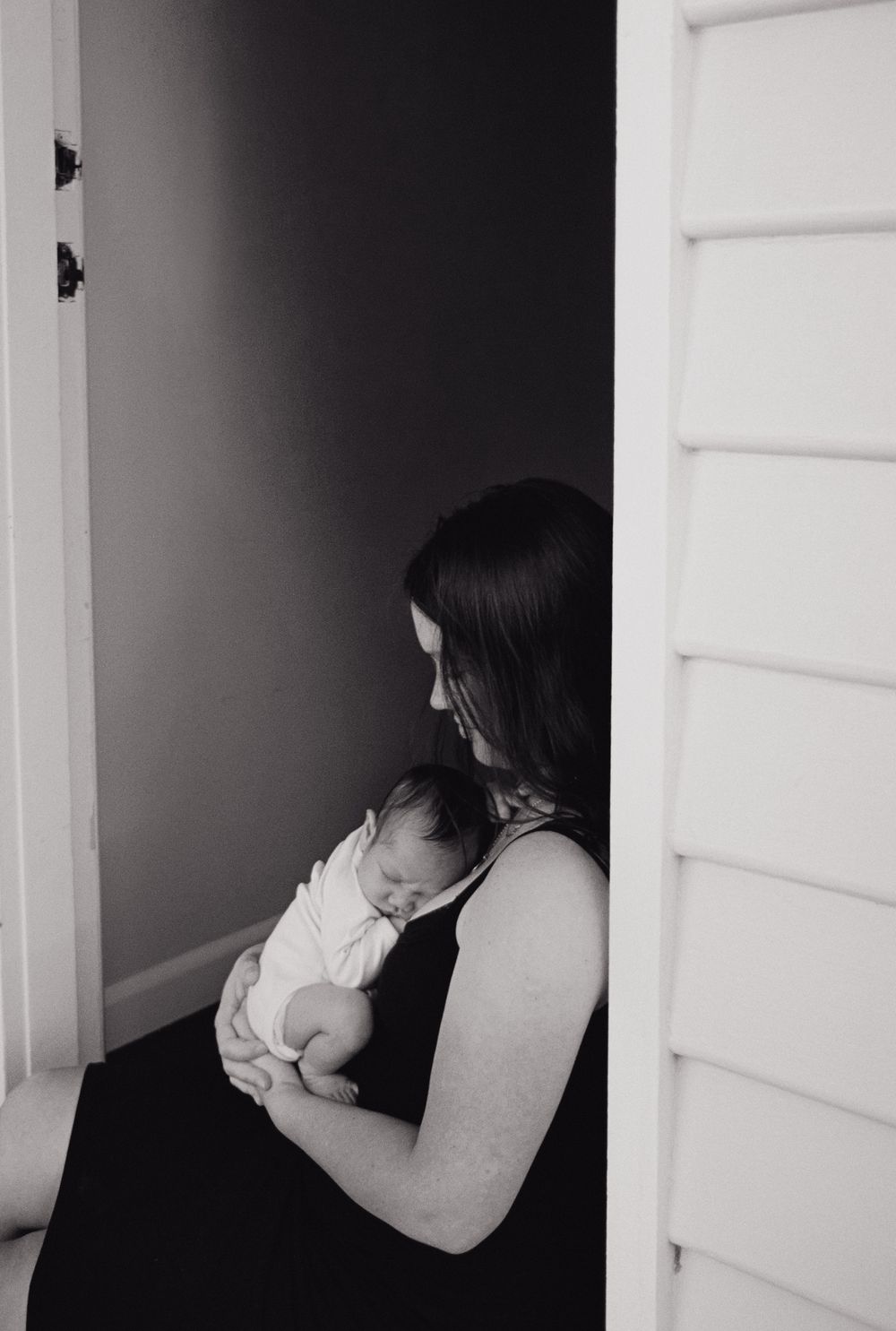 A series of black and white photos showing a person in white leaning against a dark indoor doorway or corner.