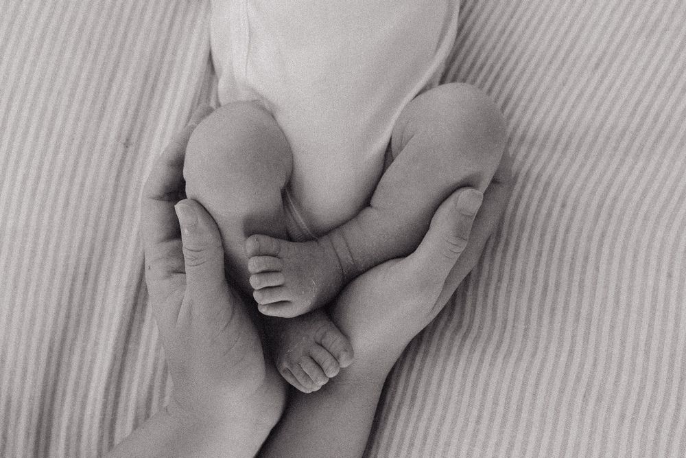 A series of black and white close-up photographs showing baby feet and toes from different angles.