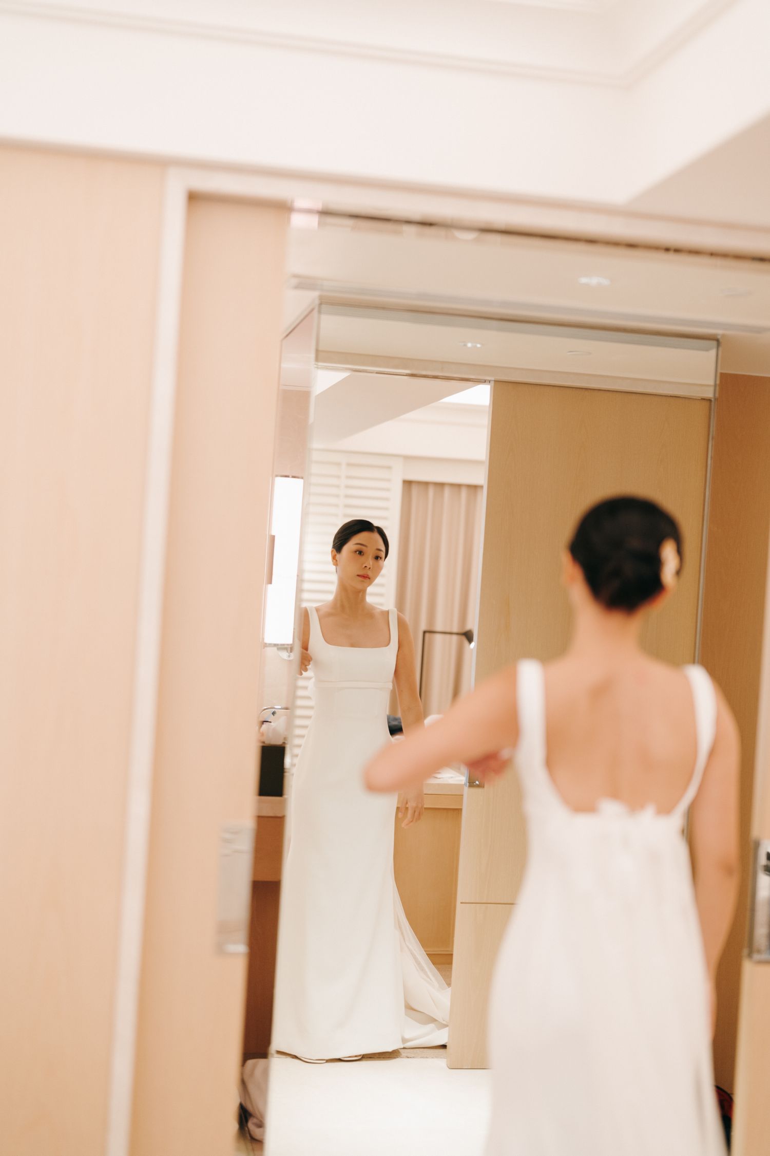 Wedding dress fittings in a bridal boutique with multiple mirrors.
