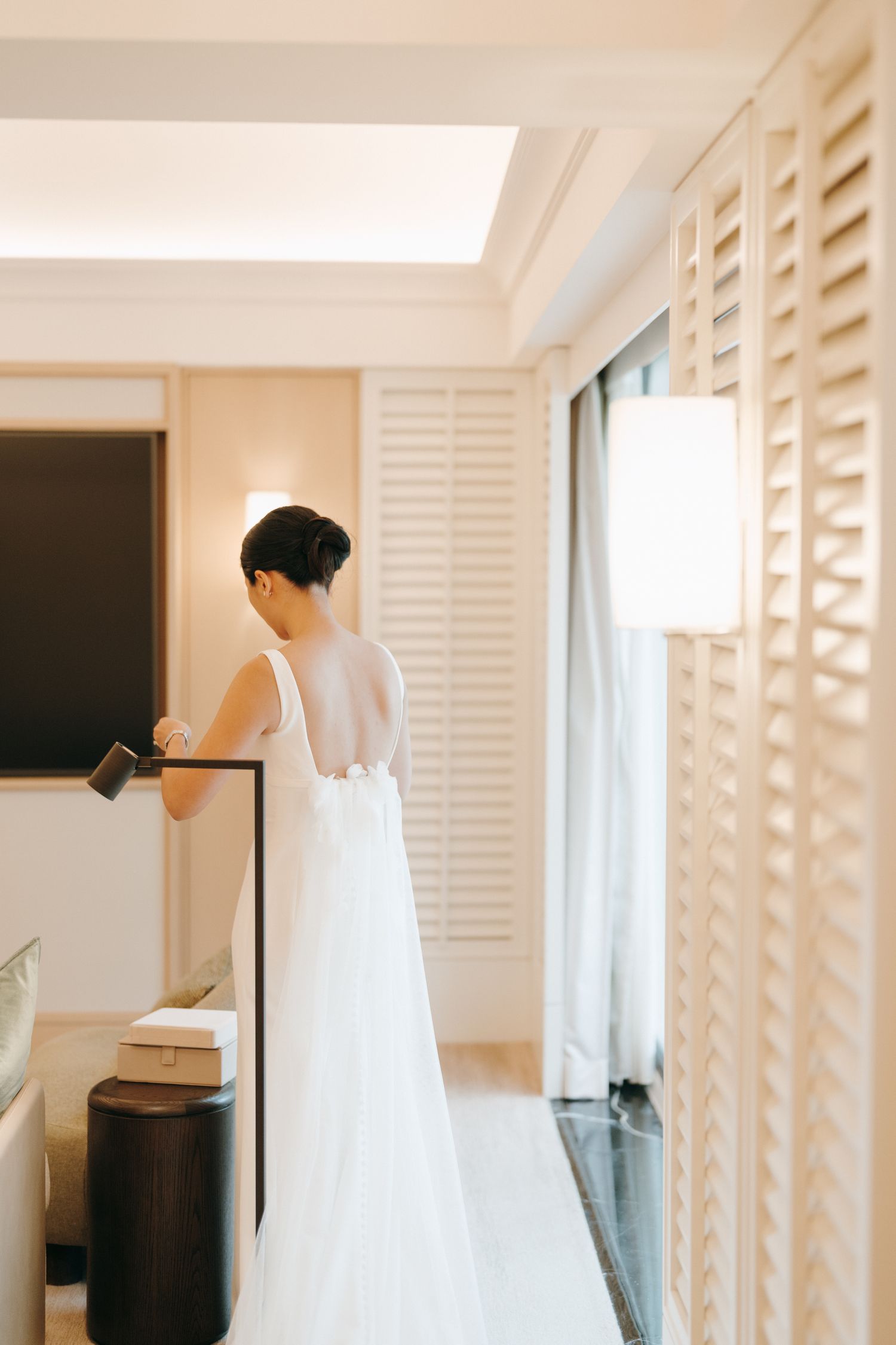 Minimalist white room with plantation shutters creating a serene getting-ready space.