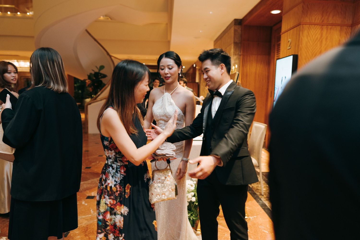 Wedding guests dance together on a wooden dance floor during an evening reception celebration.
